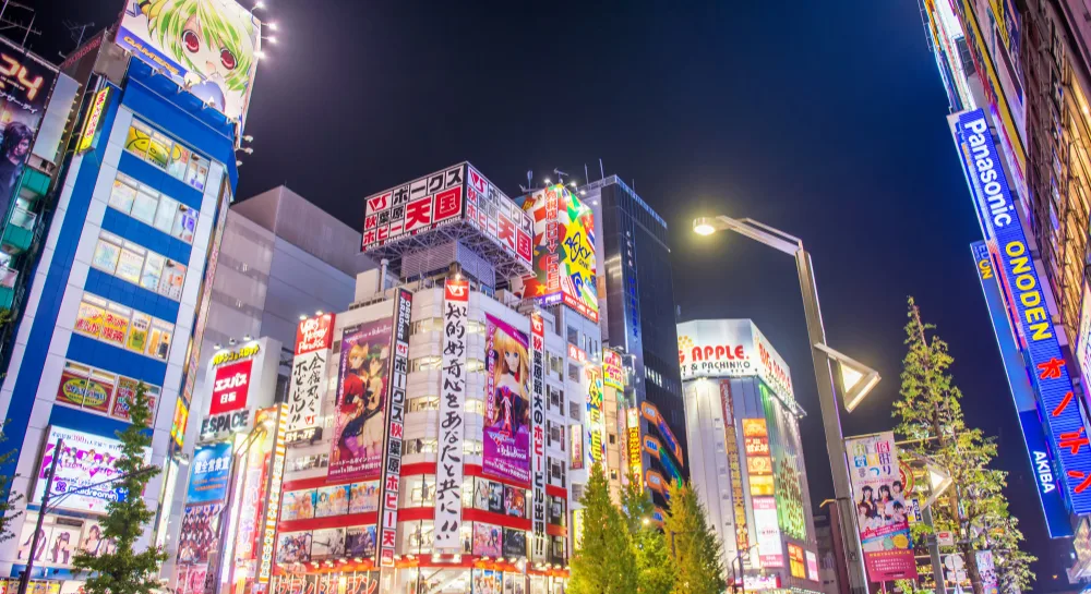 Akihabara at night with bright anime billboards, neon signs, and busy streets in Tokyo