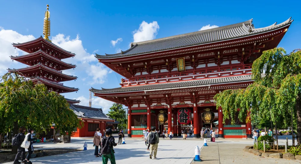 Sensoji Temple Kaminarimon Gate and five-story pagoda in Asakusa Tokyo on a clear day with visitors walking through the courtyard
